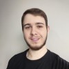 Foto de Leandro Larg, aluno do curso de Arquitetura de Informação, um homem branco de cabelo castanho curto usando barba e uma camiseta preta.