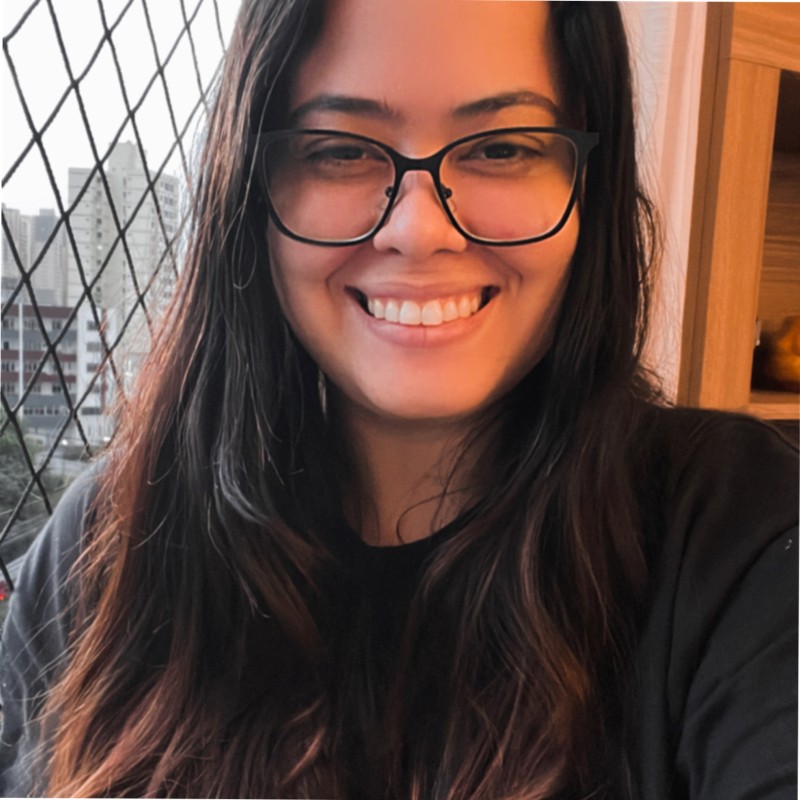 Foto de Adriene Machado, aluna do curso de Product Discovery em Dual-Track, uma mulher branca sorrindo, com cabelo castanho liso e longo e usando óculos.