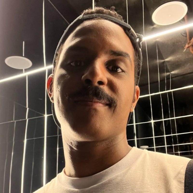 Foto de Yuhri Alves, aluno do curso de Customer Discovery em Dual-Track, um homem pardo de bigode e boné virado para trás.