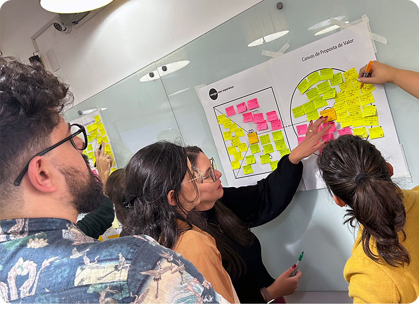 Curso UX Strategy Presencial com alunos preenchendo um canvas de proposta de valor com post-its.